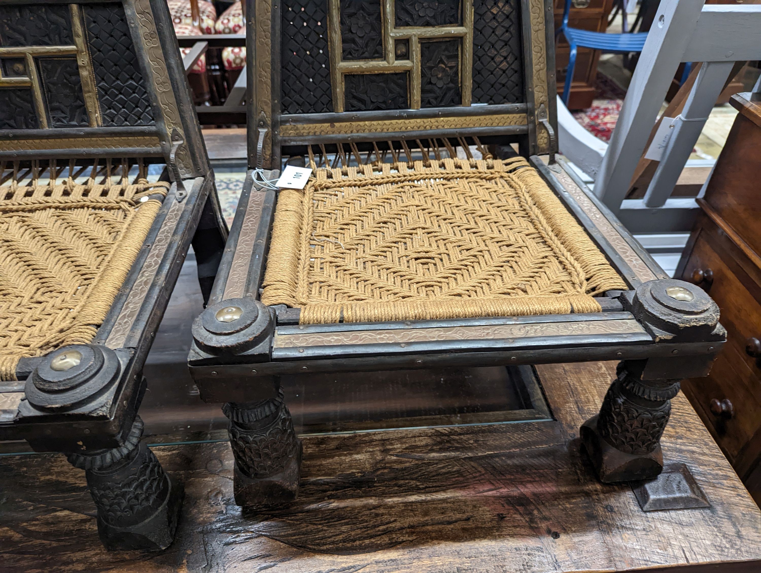 A pair of Afghan chip-carved and brass-mounted low seat chairs with woven seats, width 45cm, depth 45cm, height 76cm